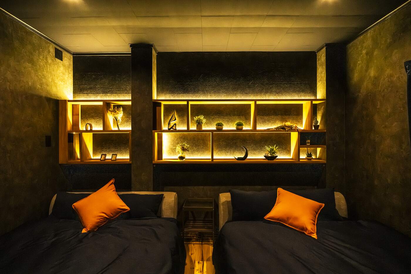 Master bedroom with twin beds and lit shelving