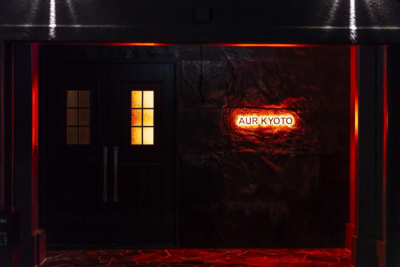 The black entrance door and ember-red AUR KYOTO sign