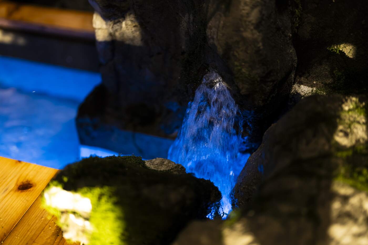 Water lit blue over rock