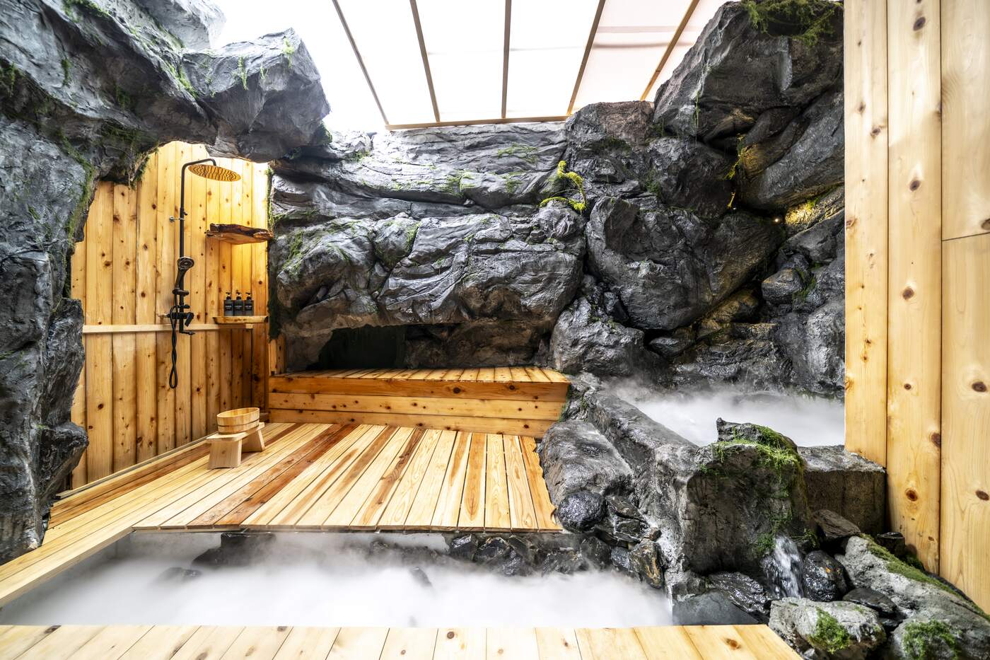 Open-air stone bath under the glass roof